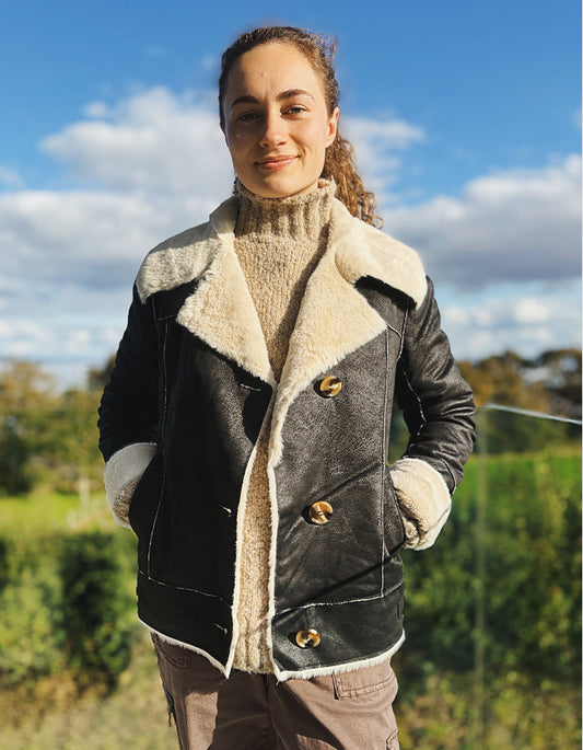 girl wearing black faux leather jacket with furry lining outside 