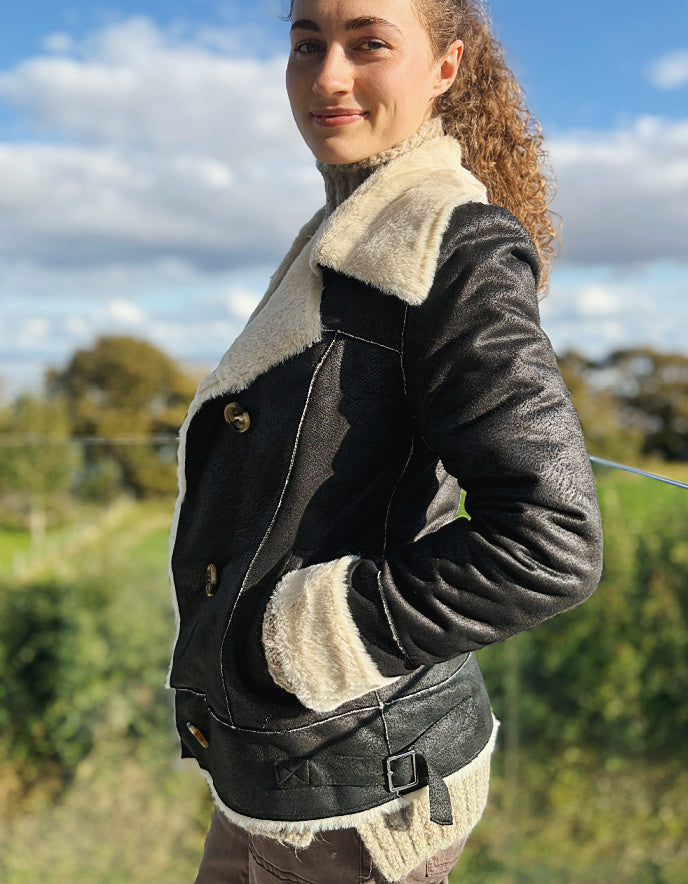 girl wearing black faux leather jacket with furry lining outside 