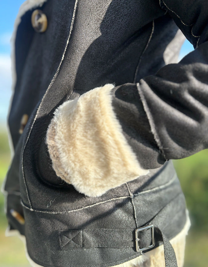 girl wearing black faux leather jacket with furry lining outside 