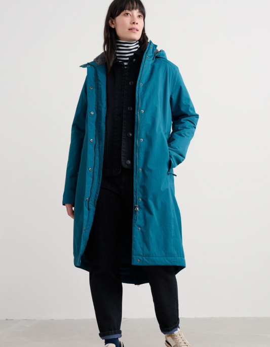 Person wearing a teal raincoat with a hood on a white background