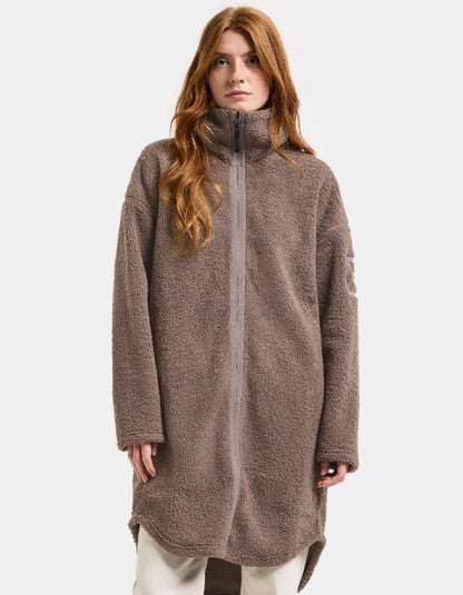 Woman wearing a brown long sherpa pile fleece coat on a white background