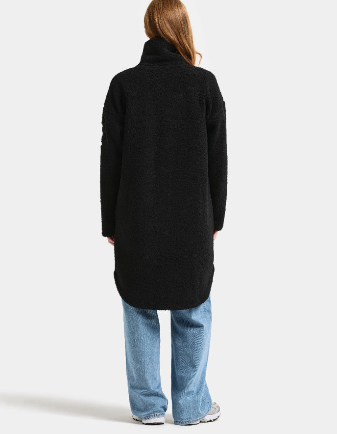Woman wearing a black sherpa pile fleece coat on a white background