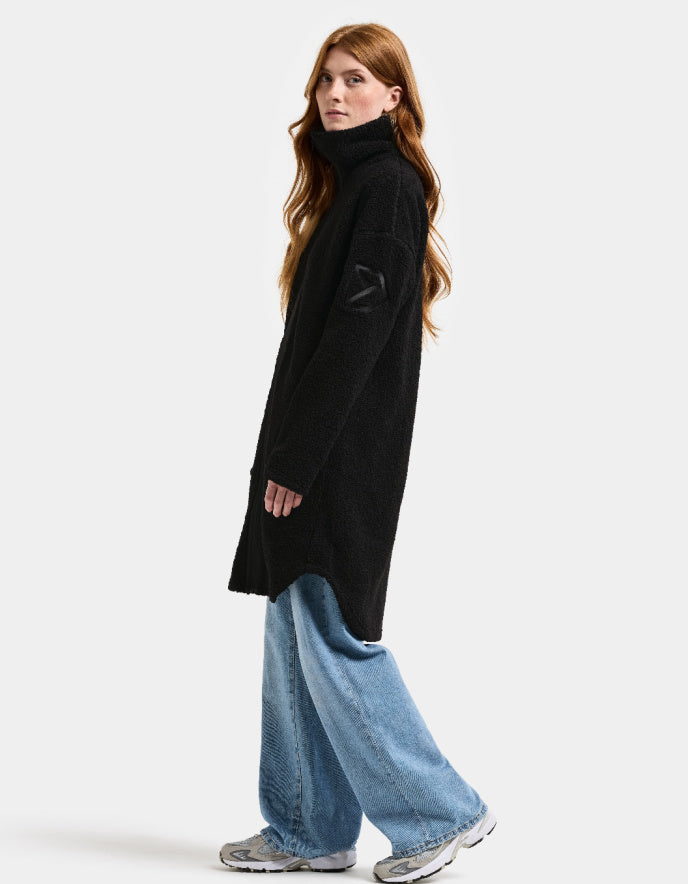 Woman wearing a black sherpa pile fleece coat on a white background