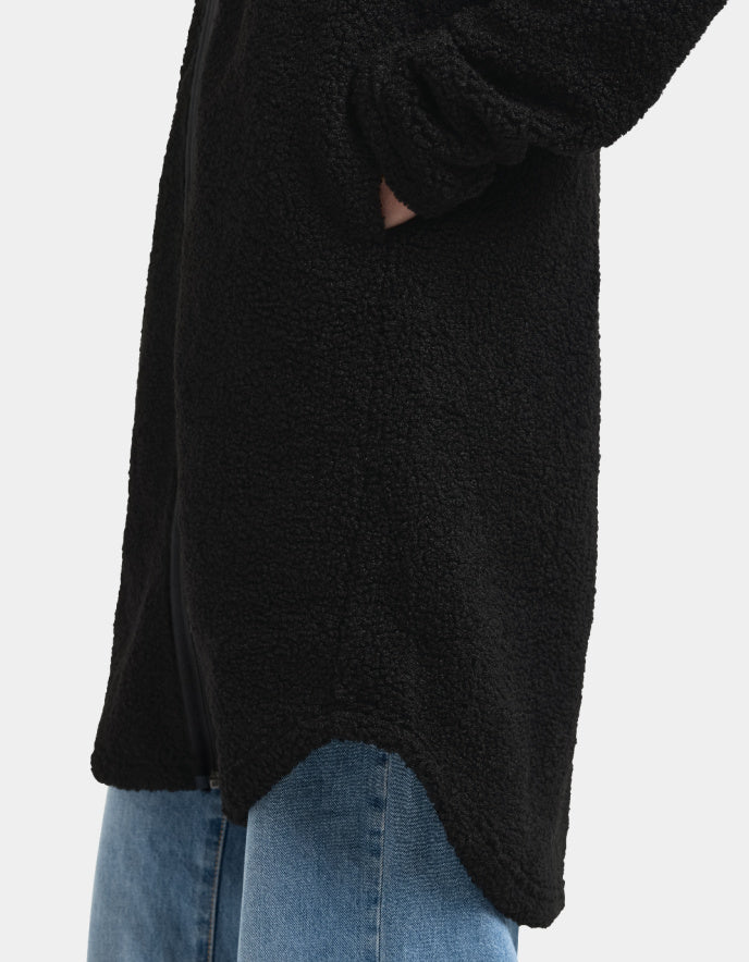 Woman wearing a black sherpa pile fleece coat on a white background