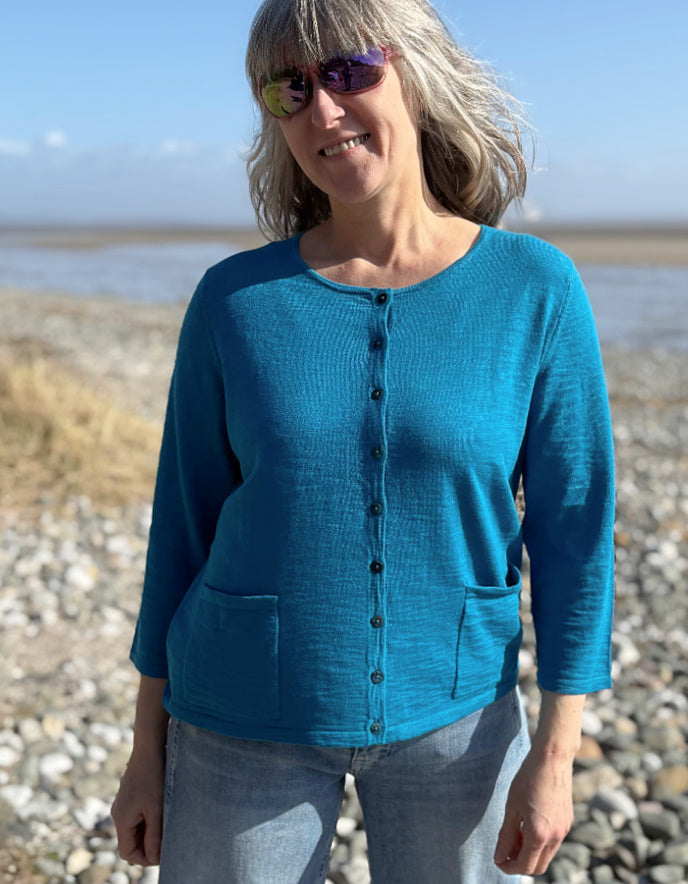 woman wearing turquoise cotton cardigan and vintage barrel leg jeans