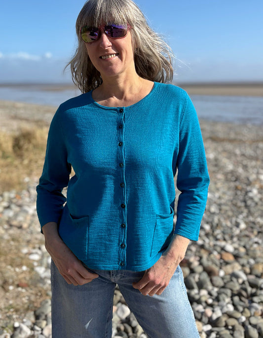 woman wearing turquoise cotton cardigan and vintage barrel leg jeans