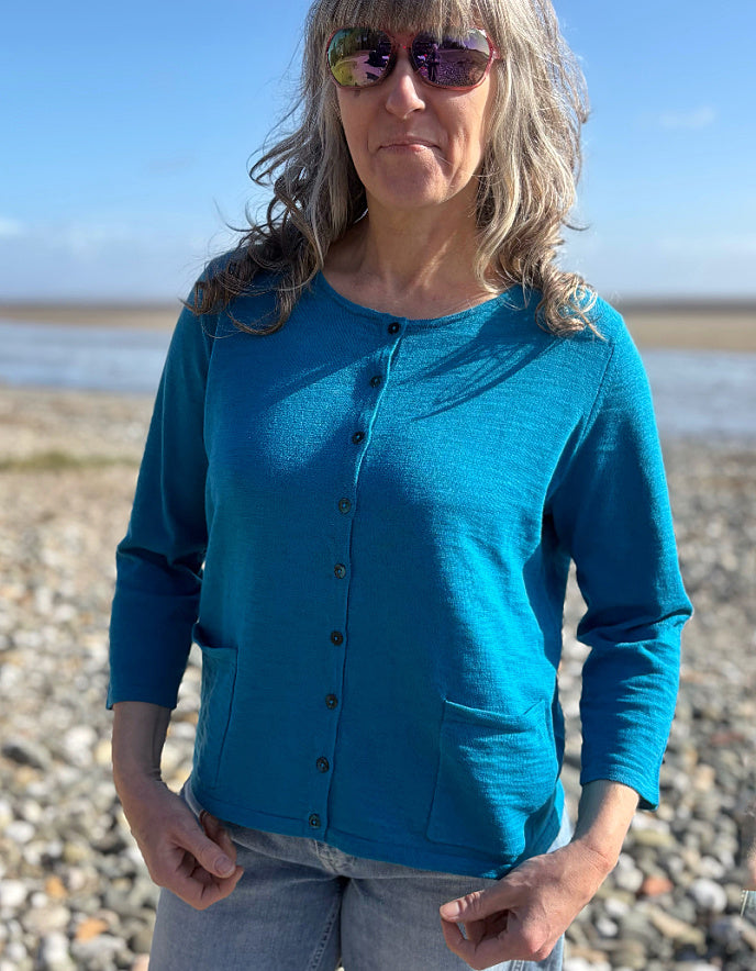 woman wearing turquoise cotton cardigan and vintage barrel leg jeans
