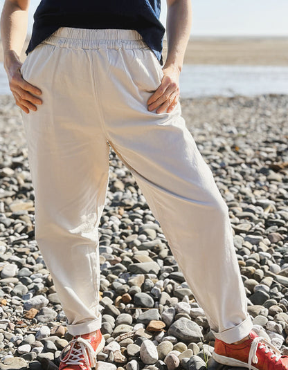 woman wearing natural cotton pants and denim tank on a beach