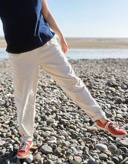 woman wearing natural cotton pants and denim tank on a beach