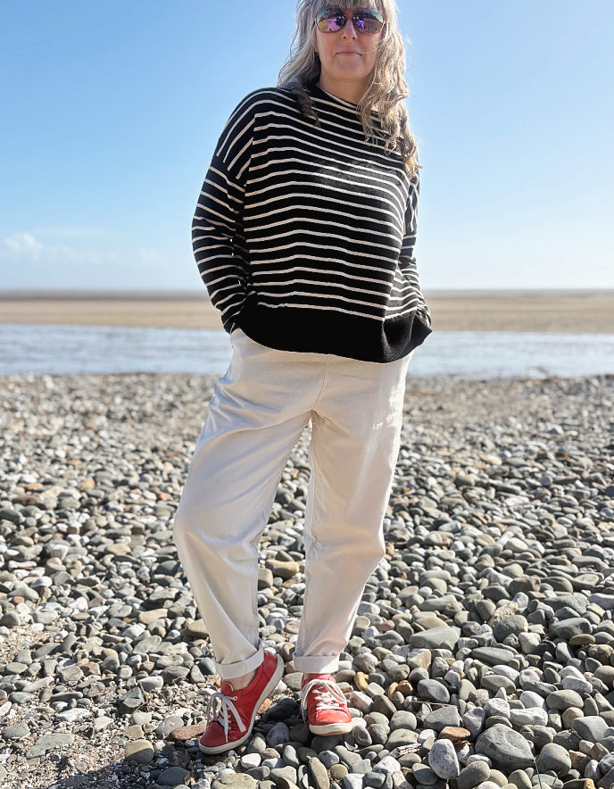 woman wearing natural cotton pants and denim tank on a beach