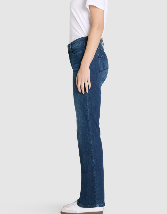 Person wearing blue jeans on a plain background