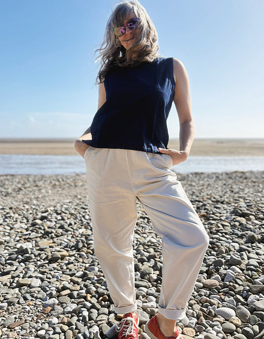 woman wearing natural cotton pants and denim tank on a beach