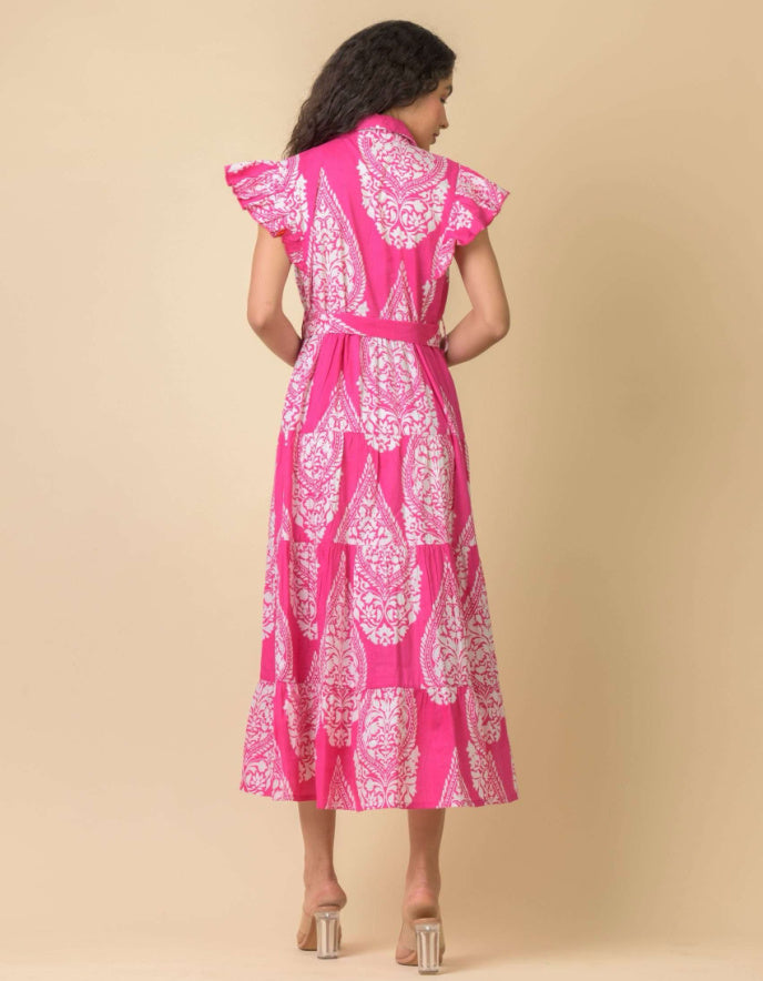 Woman wearing a pink dress with white patterns on a beige background