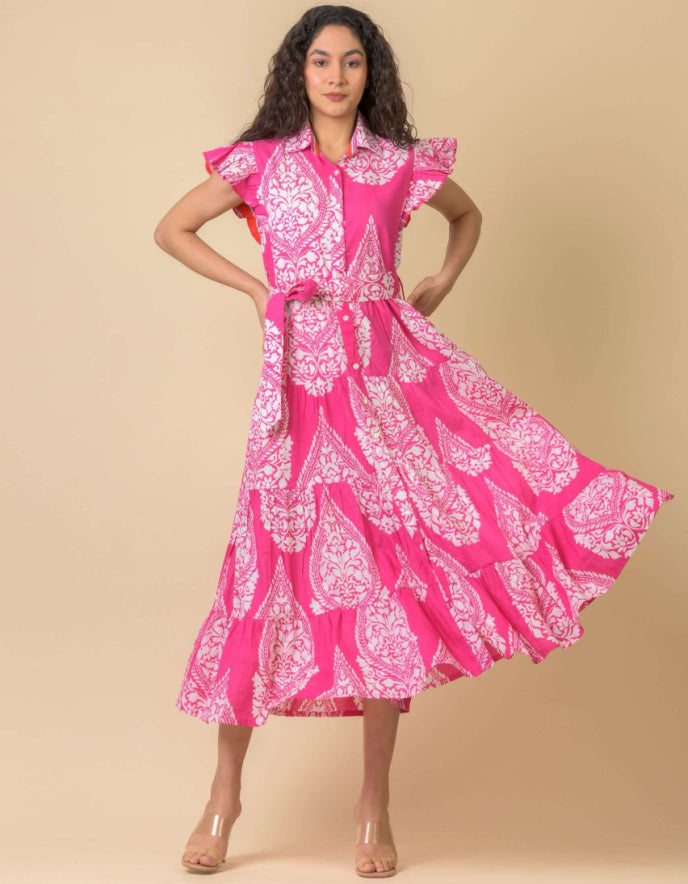 Woman wearing a pink and white patterned dress against a beige background