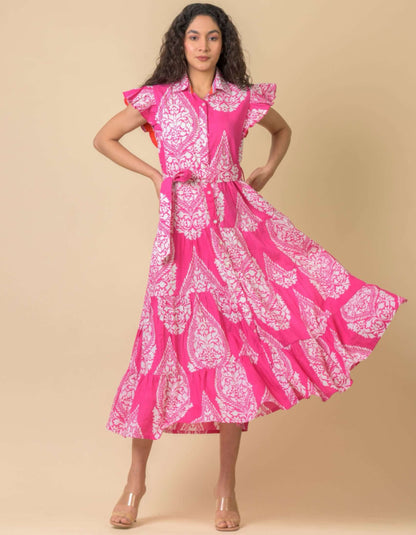 Woman wearing a pink and white patterned dress against a beige background