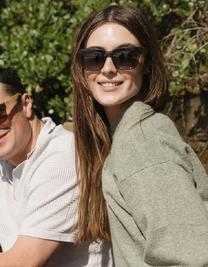 woman wearing moss green framed sunglasses with wood arms