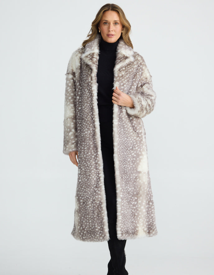 Woman wearing a long, patterned faux fur grey Bambi coat standing on a plain background