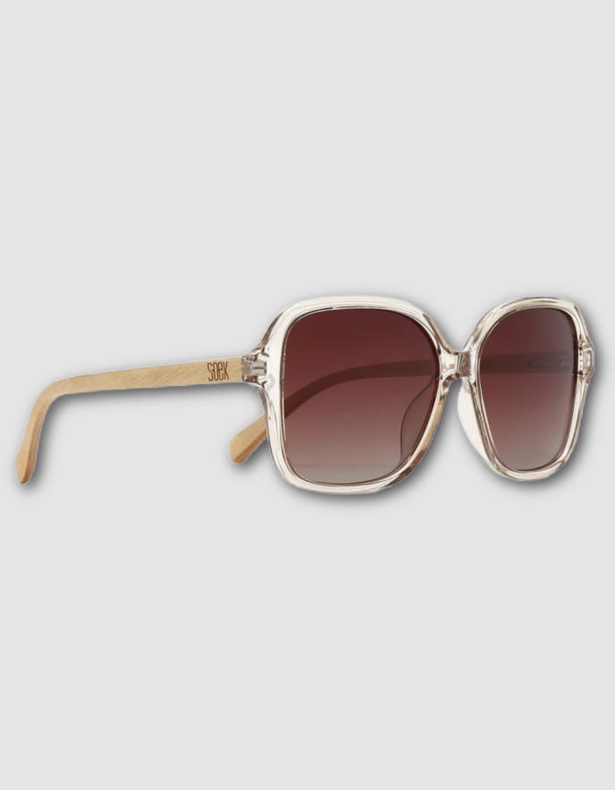 Oversized square sunglasses with a translucent light beige frame, brown gradient lenses, and light temples on a light grey background.