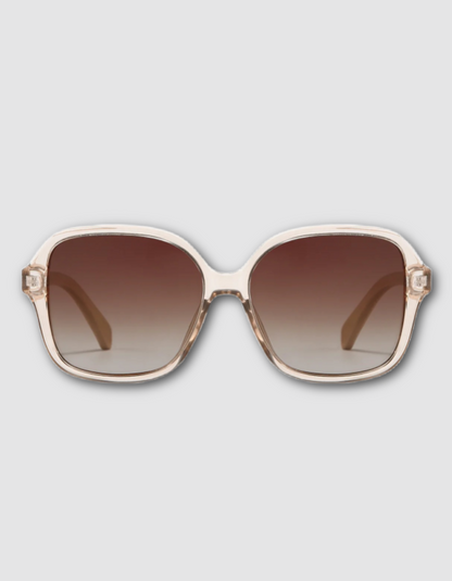 Oversized square sunglasses with a translucent off-white frame and brown gradient lenses, shown against a light gray background.