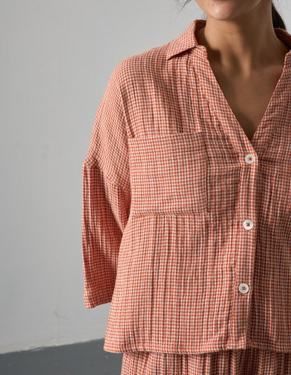 Person wearing a red and white checkered outfit against a gray background