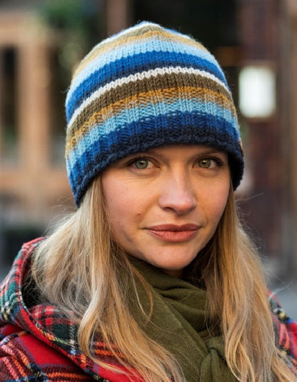 Person wearing a striped knit beanie with a blurred background