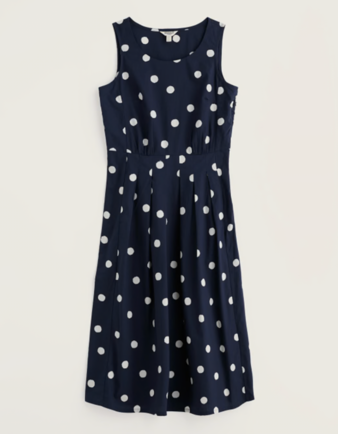 Navy dress with white polka dots on a light beige background