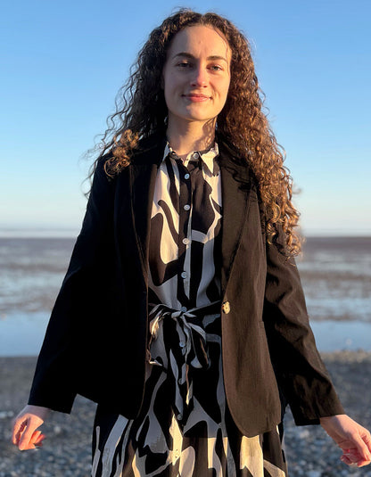 woman wearing black jacket blazer over a zebra print dress