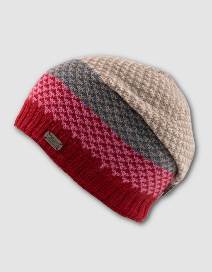 Knitted beanie with red, pink, and beige pattern on a light gray background