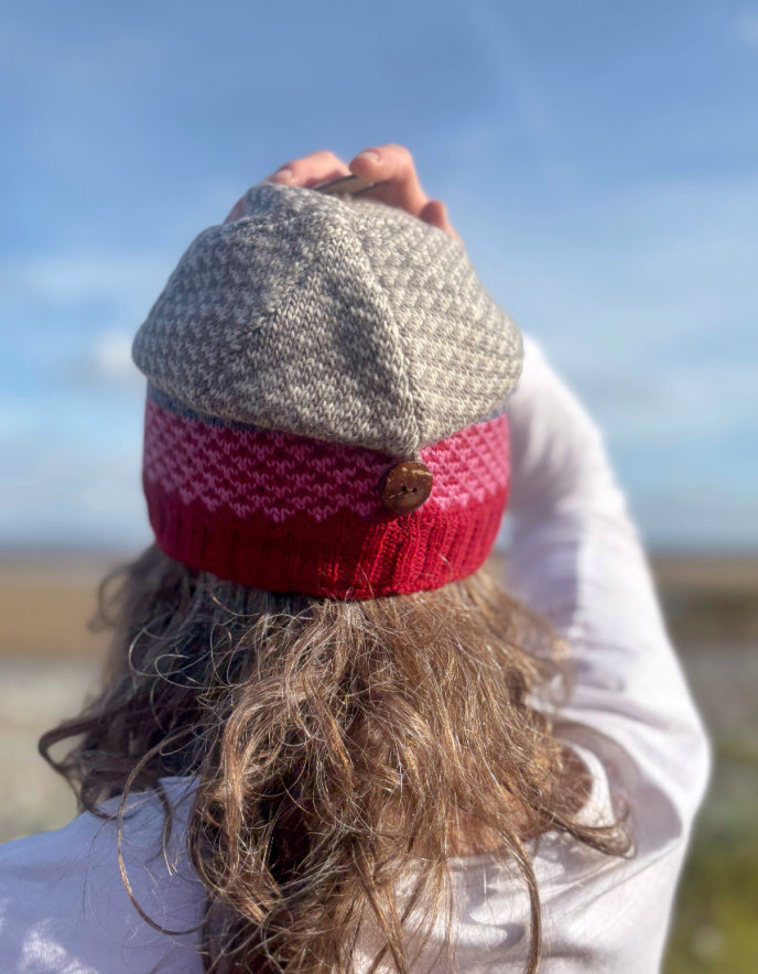 Person wearing a knitted hat with a red pattern outdoors
