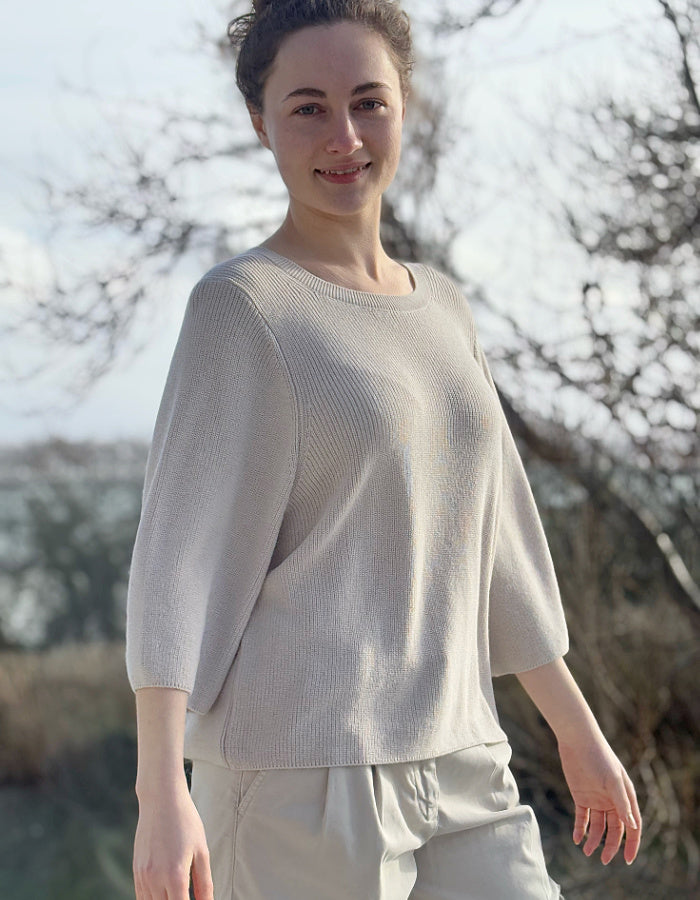 cream knit sweater with crew neckline and 3/4 sleeves