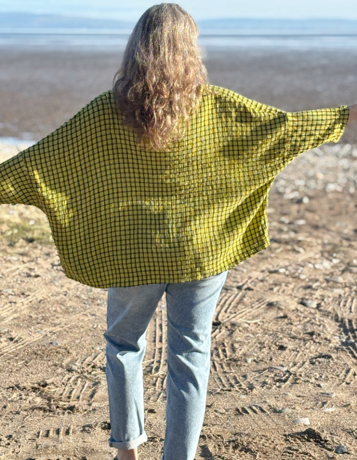 oversized one size top with drape. ochre shade of green with black check print, round neckline