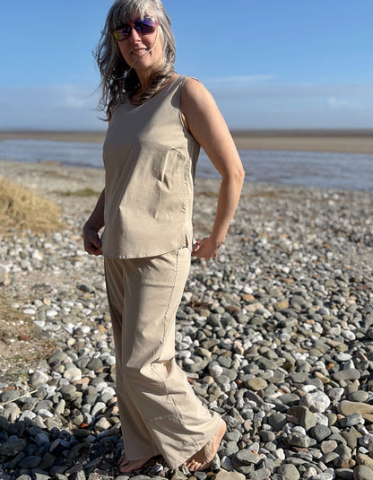 woman wearing sand tank top and matching trouser on a beach