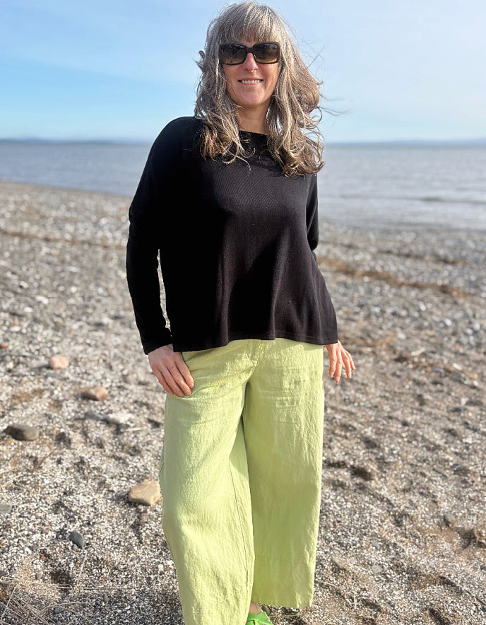 boxy black knit sweater with soft green trousers 