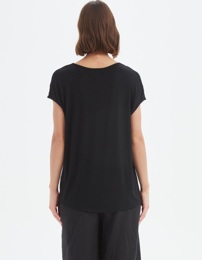 Person wearing a black t-shirt and pants on a white background