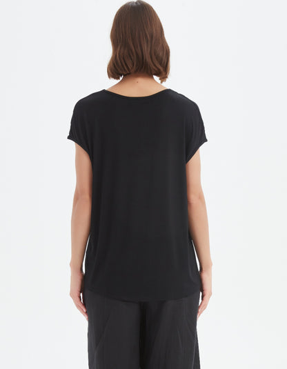 Person wearing a black t-shirt and pants on a white background