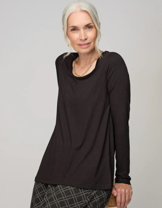 Woman wearing a black long-sleeve top against a plain background