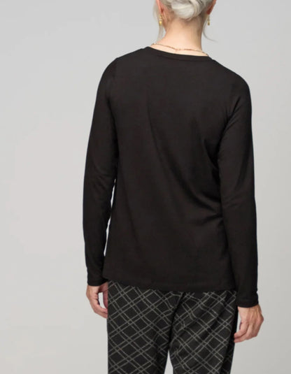 Person wearing a black long-sleeve shirt and plaid pants on a gray background