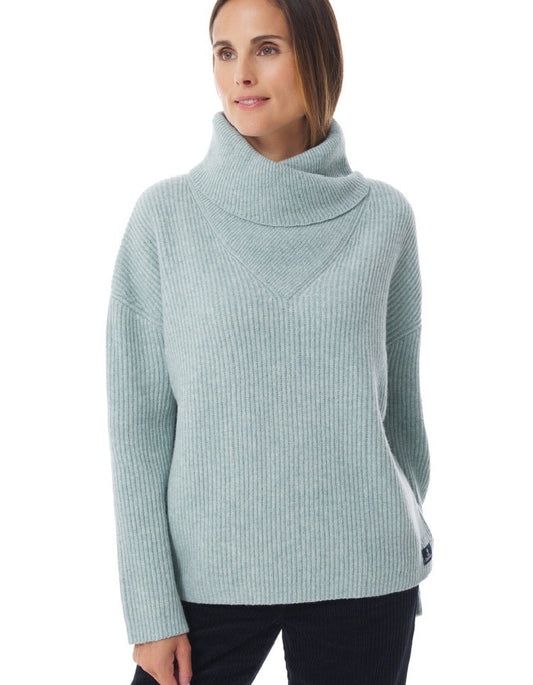 Woman wearing a light blue ribbed sweater on a white background