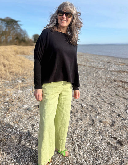 boxy black knit sweater with soft green trousers 