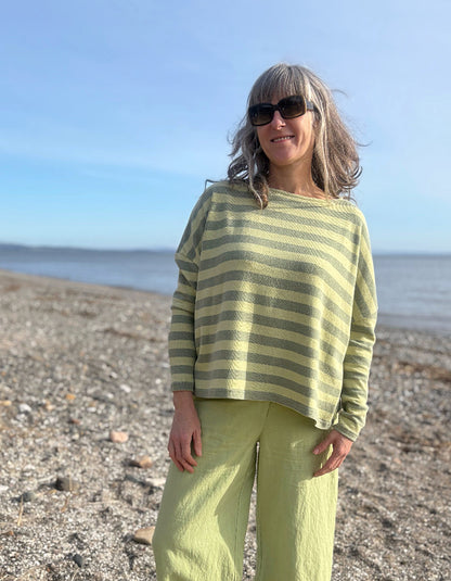 woman wearing stripe green and yellow boxy knit jumper with soft green wide leg trousers