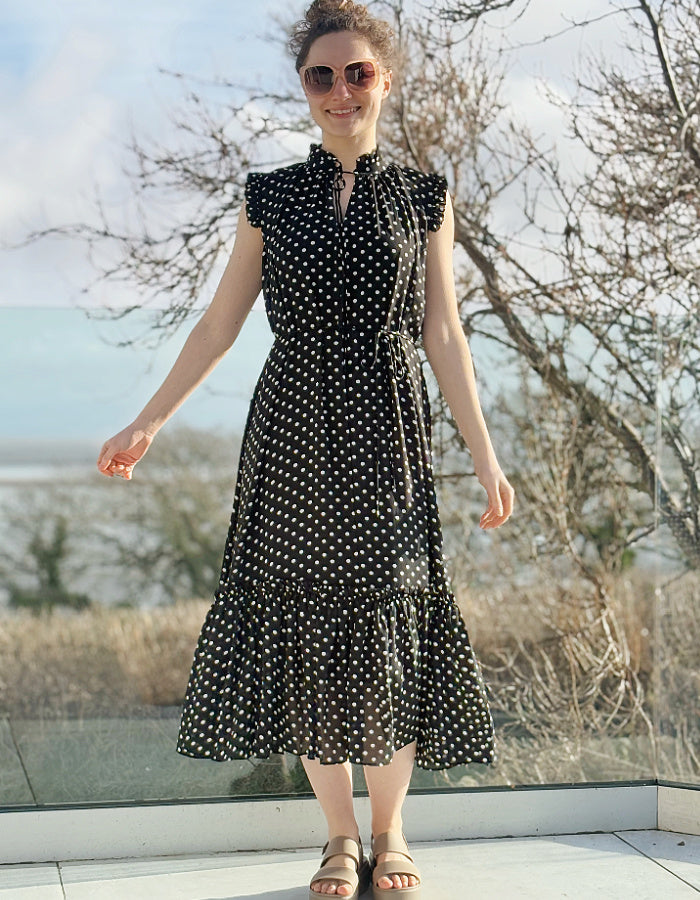 black and white polka dot midi length sleeveless dress with deep ruffle hem