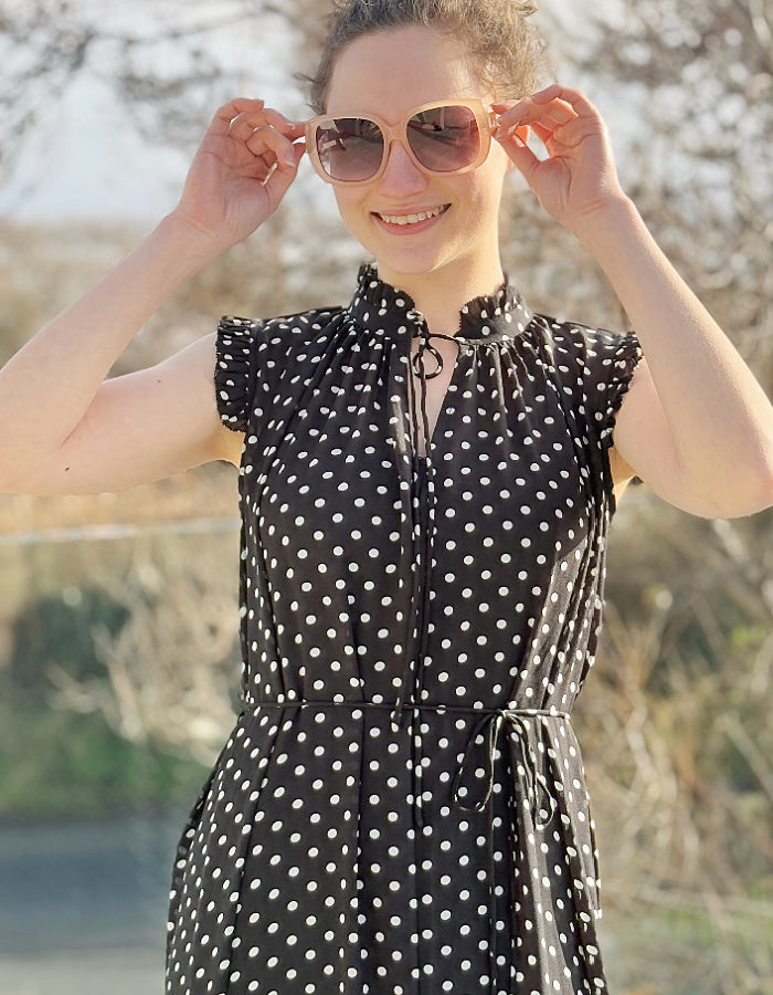 black and white polka dot midi length sleeveless dress with deep ruffle hem