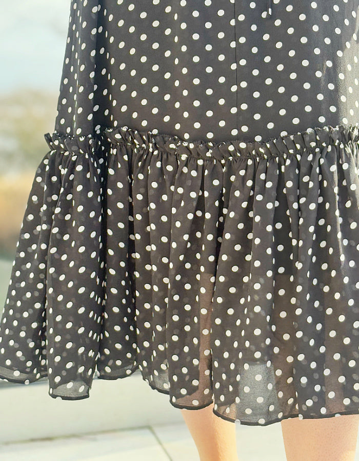 black and white polka dot midi length sleeveless dress with deep ruffle hem