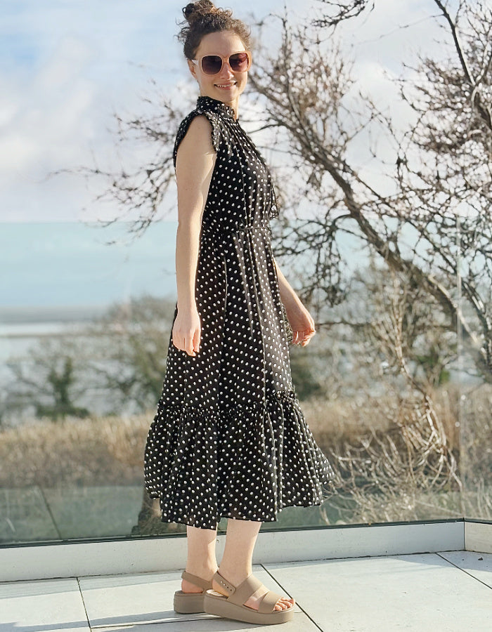 black and white polka dot midi length sleeveless dress with deep ruffle hem