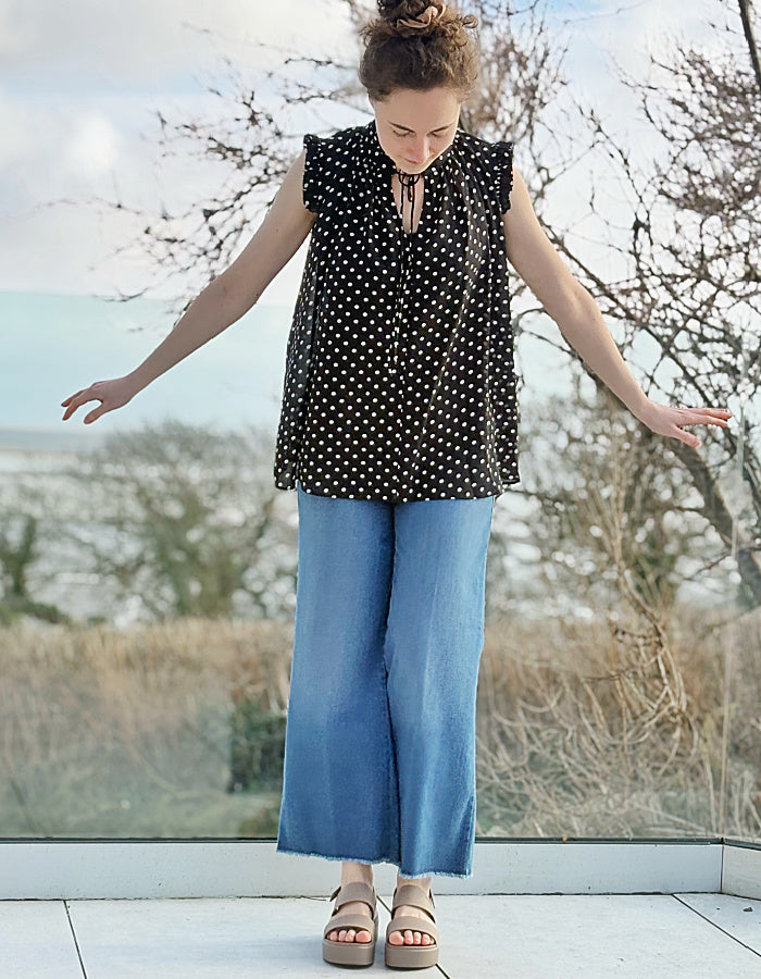 black and white polka dot chiffon sleeveless top with ruffle edged detail