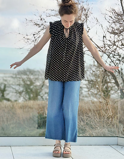 black and white polka dot chiffon sleeveless top with ruffle edged detail