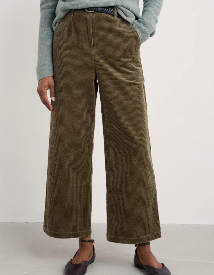 Person wearing brown corduroy pants on a white background