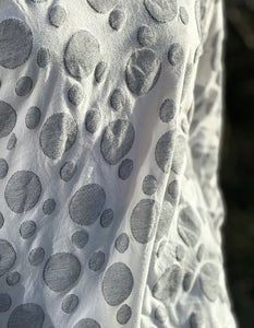white cotton long sleeve top with scoop neckline with woven graphic grey bubble print all over