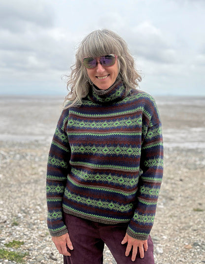 Person wearing a Fair Isle patterned sweater on a beach