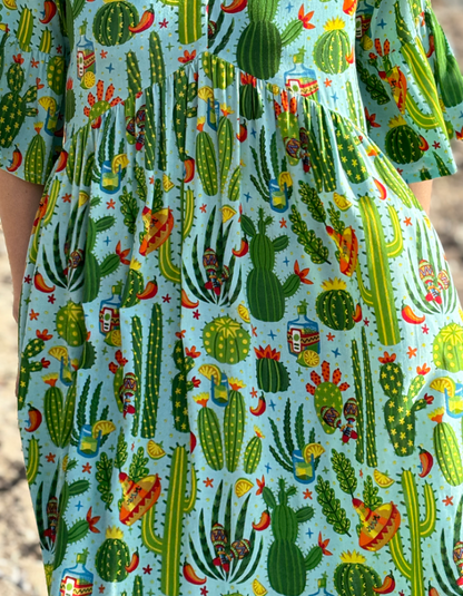 lime green loose fit maxi dress with 3/4 sleeves with frilled edges print includes bright colours cactus, chillis and sombreros